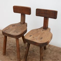 two wooden chairs sitting next to each other