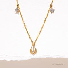 a gold necklace with two stars and a star on the bottom, hanging from a chain