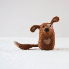 a small stuffed animal sitting on top of a bed