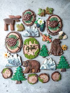 decorated cookies are arranged in the shape of trees, mountains and other things on a table