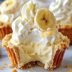 there is a banana cream pie with whipped cream and bananas on top that has been cut in half