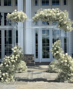 the entrance to a house with white flowers on it