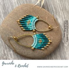 two pairs of beaded earrings sitting on top of a rock