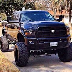 a large black truck parked on the side of a road