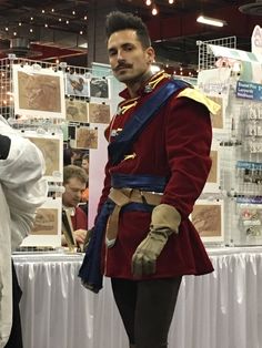 a man in a red uniform standing next to a table