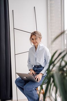 a woman sitting on a chair with her laptop