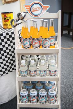 a shelf filled with bottles and glasses on top of a carpeted floor next to a checkered table cloth