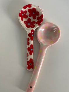 two spoons with red flowers on them are next to each other, one is empty