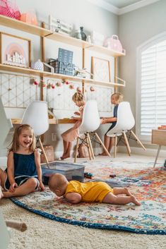 two children are sitting on the floor in front of their laptops and playing with each other