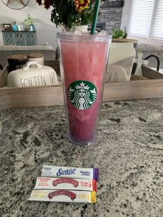 a pink drink sitting on top of a counter next to some candy bar wrappers