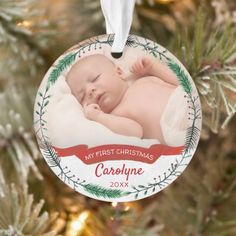 a baby's first christmas ornament hanging from a christmas tree