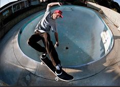 a man riding a skateboard up the side of a cement ramp at a skate park