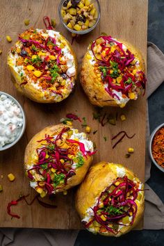 three baked breads with different toppings on a cutting board next to bowls of condiments