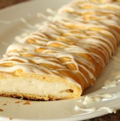 a white plate topped with a pastry covered in icing