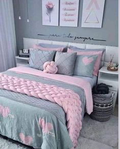 a bed with pink and grey comforters in a bedroom