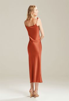 a woman in an orange dress looking back