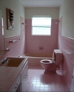 a bathroom that has pink tiles on the walls