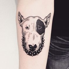 a black and white dog tattoo on the right arm, with a collar around it's neck