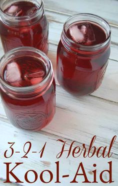 three jars filled with kool - aid sitting on top of a white wooden table