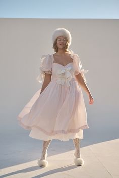 Shipping delay: Please allow 7-10 business days for this style to ship. Look as delectable as a cherry blossom-infused macaron in the Confection Cottontail—a blush cotton midi-dress with puff sleeves and a pleated skirt. The contrasting bows and luscious ruffles harken back to a New Year’s celebration amid French arist Fitted Dress With Pink Bow For Spring, Pink Puff Sleeve Midi Dress For Garden Party, Pink Midi Dress With Ruffles And Fitted Bodice, Fitted Marie Antoinette Style Spring Dress, Marie Antoinette Style Fitted Spring Dress, Princesscore Ruffled Dresses For Garden Party, Princesscore Ruffle Dress For Garden Party, Pink Pleated Puff Sleeve Dress, Pink Pleated Dress With Puff Sleeves