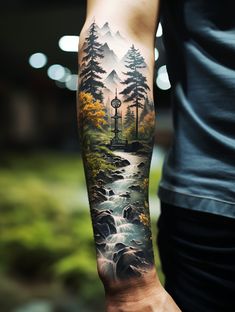 a man's arm with a forest scene on it and a river running through it