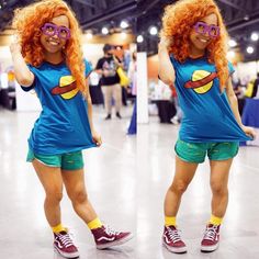 a woman with red hair and glasses is standing in front of a mirror wearing green shorts