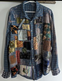 a shirt that is hanging up on a wall with many different colored patches and designs