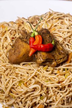 a white plate topped with noodles and meat