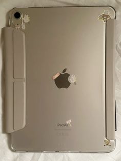 an apple ipad is sitting on top of a white sheet with the back cover removed