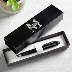 a pen sitting in a box on top of a table next to a potted plant