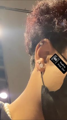 a woman with ear piercings in front of a mirror