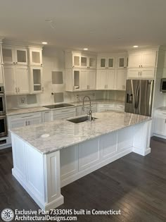 a large kitchen with white cabinets and marble counter tops