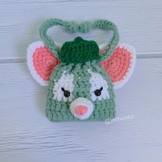 a crocheted green and white hat with an elephant's head on it