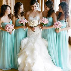 a group of women standing next to each other holding bouquets