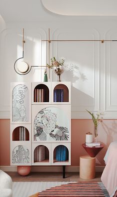 a room with pink walls and white furniture, including a bookcase filled with books