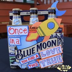 blue moon beer in a cardboard box with stickers on the front and bottom, sitting on top of a table