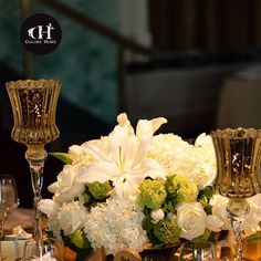 a centerpiece with flowers and candles on a table