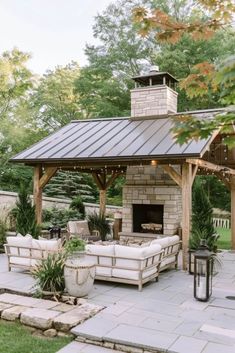 an outdoor living area with couches and a fire place in the middle of it