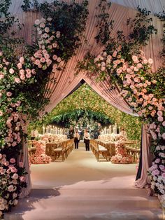 an outdoor wedding ceremony with flowers and candles on the aisle, surrounded by greenery