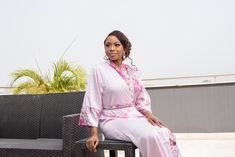 DESIGNER’S NOTE: This elegant pink kimono is crafted from pink lustrous satin paired with a printed floral pink satin that feels so smooth against your skin. We can't think of anything more luxurious to wear while you're getting ready on your wedding day. Designed to flatter your curves. Comfy chic. FIT: Slightly loose for a relaxed fit. Select your normal size ATTRIBUTES: Robe Length: 56 inches Model Stats: 5 ft 6, US 6 wearing a Medium size Color: Pink Fabric: Satin Print: Peacock design Sleev Feminine Wedding Robe With Kimono Sleeves, Pink Kimono For Spring Wedding, Spring Wedding Pink Kimono, Elegant Pink Wedding Robe, Elegant Pink Kimono For Loungewear, Pink Silk Kimono For Wedding, Pink Elegant Kimono For Loungewear, Pink Silk Wedding Kimono, Spring Wedding Satin Kimono