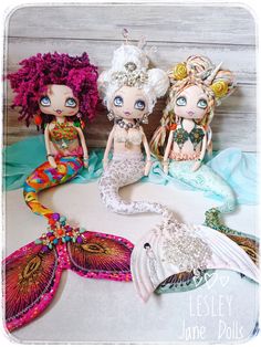 three little mermaid dolls sitting next to each other