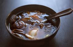 a bowl filled with soup sitting on top of a wooden table