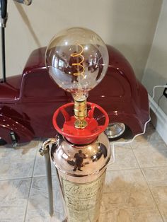 an old fashioned lamp sitting on top of a metal tank