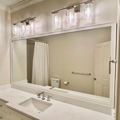 a bathroom with a sink, mirror and lights