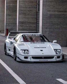 a white sports car parked in front of a building