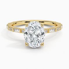 a yellow gold engagement ring with an oval cut diamond and side stones on the band