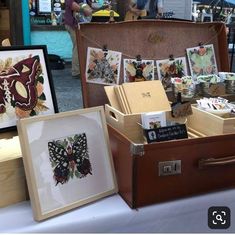 an open suitcase sitting on top of a table filled with cards and pictures next to other items