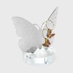 a white angel figurine sitting on top of a clear base with gold accents