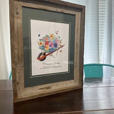 a wooden frame holding a painting on top of a table