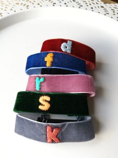 four different colored headbands with sequins on them sitting on a white plate